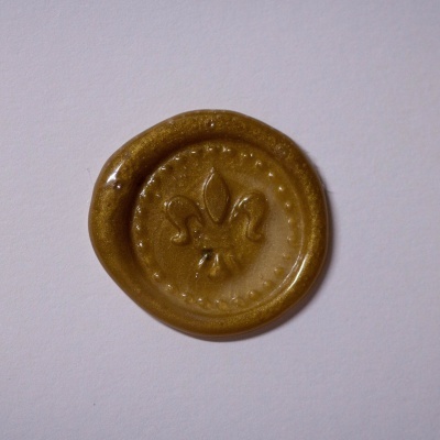 Selo em cera dourado com flor-de-lis em relevo