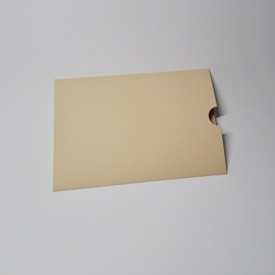 Envelope bege de papel com recorte semicircular sobre superfície branca