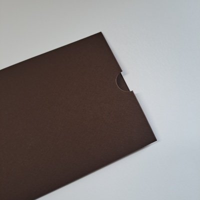 Envelope castanho de papel com recorte semicircular sobre superfície branca