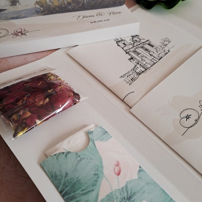 Convite de casamento com ilustração de igreja, pétalas secas e embalagem decorativa