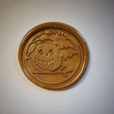 Selo de lacre castanho com relevo de coruja sentada num ramo