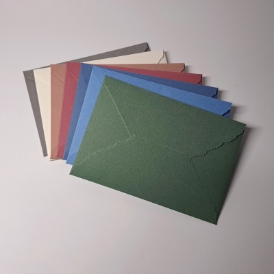 Envelopes coloridos texturizados sobre superfície branca