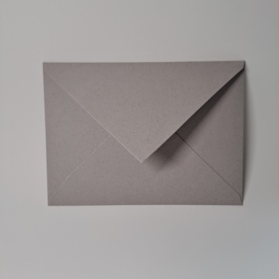 Envelope cinza de papel reciclado sobre superfície branca