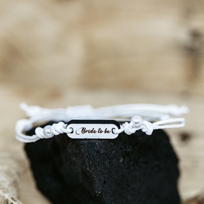 pulseira branca com placa metálica e pérola