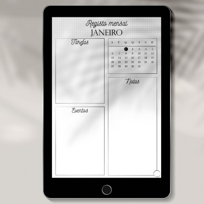 Tablet preto com calendário mensal digital em português no ecrã e sombra de plantas ao fundo