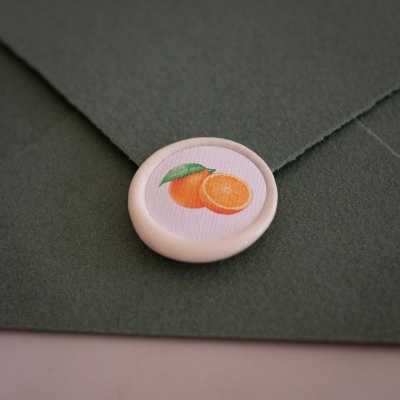Envelope verde com selo branco ilustrado com laranjas