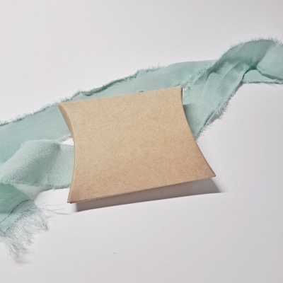 Caixa de papel castanho com tecido azul esverdeado