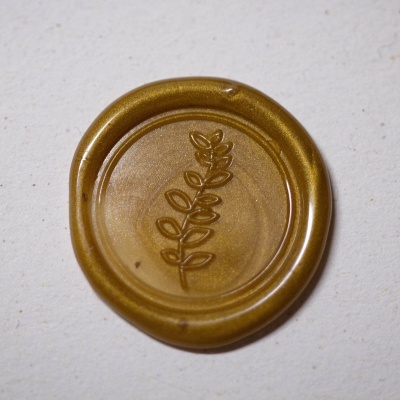 Selo de cera dourada com ramo em relevo