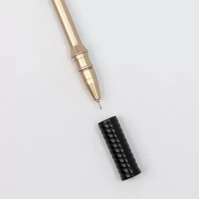 Caneta com corpo dourado e tampa preta texturizada