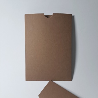 Envelope de papel castanho com abertura semicircular sobre superfície branca