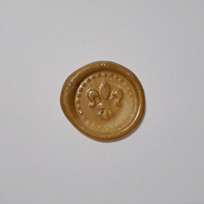Selo de cera amarelo dourado com flor-de-lis em relevo