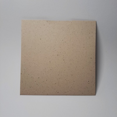 Folha quadrada de papel cartão castanho claro com pontos pretos sobre fundo branco