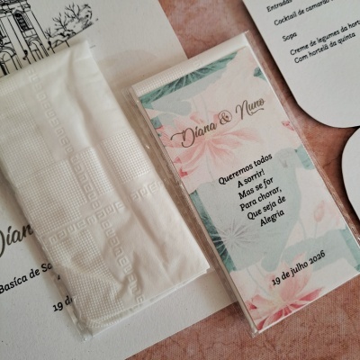 Embalagens com guardanapos de papel e papel decorativo floral com texto em português.