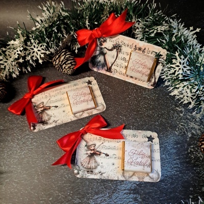 Porta-chocolates de Natal com laços vermelhos e motivos infantis tocando violino
