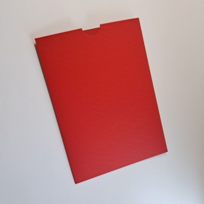 Envelope ou pasta vermelha texturizada sobre superfície branca
