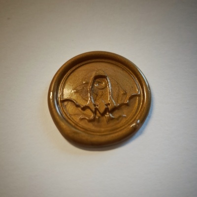 Selo redondo de cera castanha com morcego em relevo