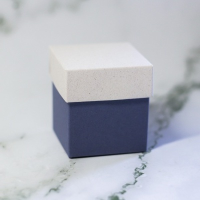 Caixa pequena cubo branca e azul em superfície de mármore
