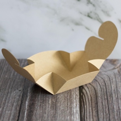 Caixa dobrável de papel castanho claro sobre superfície de madeira escura