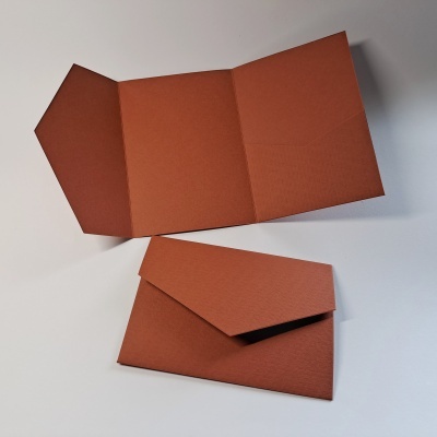 Dois envelopes castanhos, um aberto e outro fechado, sobre uma mesa branca