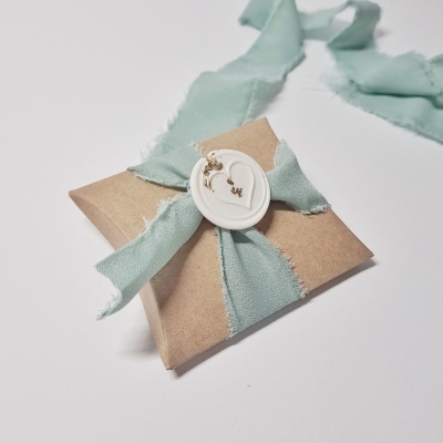 Caixa de papelão com fita verde e selo branco decorado