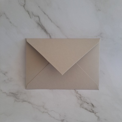 Envelope castanho claro sobre superfície marmorizada branca