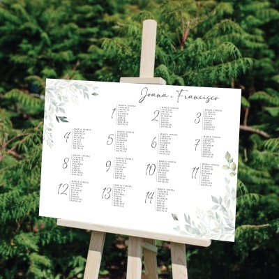 Quadro branco com folhas verdes e texto preto em suporte de madeira