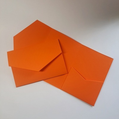 Dois envelopes laranja, um aberto e um fechado, sobre fundo branco.