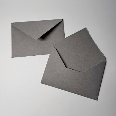 Dois envelopes cinzentos, um aberto e outro fechado, sobre fundo branco.