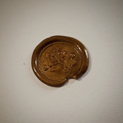 Selo de lacre castanho redondo com relevo em superfície branca