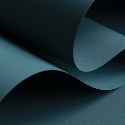 Papel azul-escuro enrugado e curvado sobre fundo azul-escuro