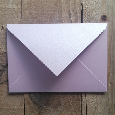 Envelope roxo claro sobre superfície de madeira
