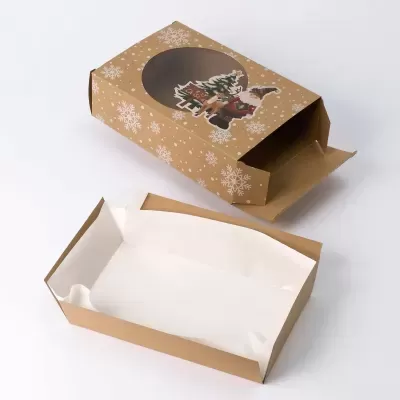 Embalaem de cartão castanha com decoração natalícia e janela transparente junto a bandeja retangular de cartão forrada a papel branco