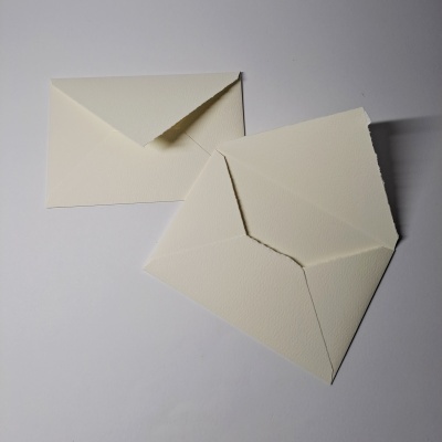 Dois envelopes creme, um fechado e outro aberto, sobre fundo branco