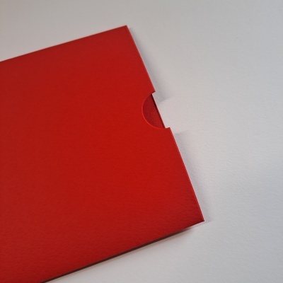 Envelope vermelho de papel sobre superfície branca