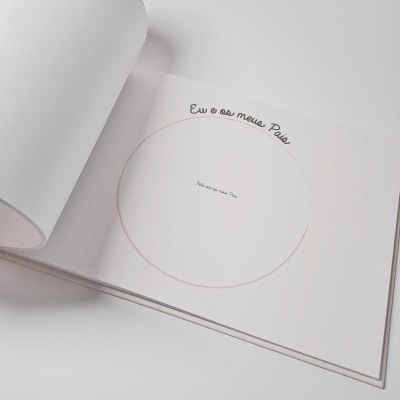 Página aberta de livro ou álbum branco com moldura circular rosa e texto em português