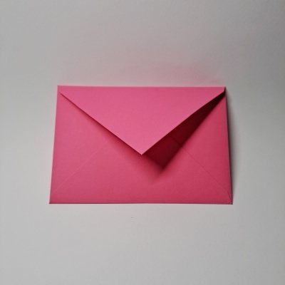Envelope rosa fechado sobre superfície branca