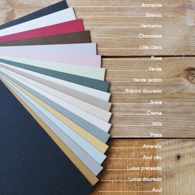 Painéis coloridos de cartão em várias cores dispostos em leque sobre madeira