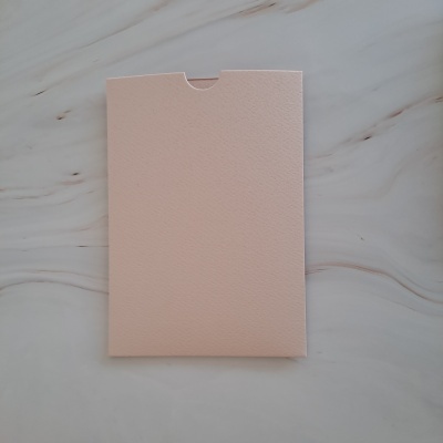 Envelope cor de rosa claro com textura sobre mármore branco
