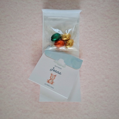 Pacote com ovos de chocolate coloridos e etiqueta decorativa para batizado