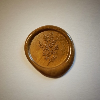 Selo de cera marrom com relevo de planta