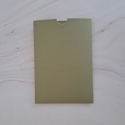 Envelope verde claro com textura sobre superfície branca