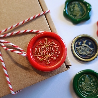 Selos de cera coloridos com temas natalinos em embalagem de presente