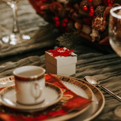 Conjunto de chá com chávena, prato, colher e caixa decorativa num ambiente de mesa posta