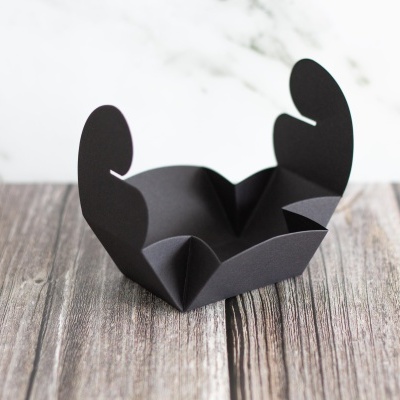 Caixa pequena dobrável preta em papel com abas arredondadas