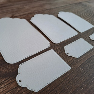 Etiquetas de papel branco de vários tamanhos sobre madeira escura