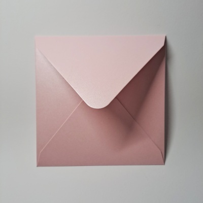 Envelope quadrado rosa em papel sobre superfície branca