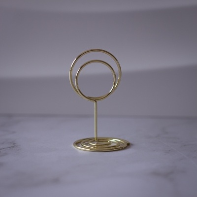 Suporte dourado com dois aros circulares sobre base redonda