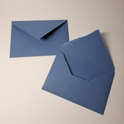 Dois envelopes azuis sobre superfície branca, um aberto e rasgado, outro fechado.