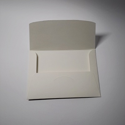 Envelope aberto de papel branco sobre superfície branca