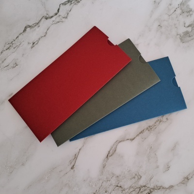 Três capas coloridas de papel sobre mármore claro